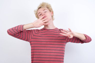 Genç sarışın adam kendini beğenmiş ve mutlu bir şekilde gülümseyerek sekiz numarayı işaret ediyor..