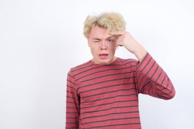 Alnındaki sivilceden mutsuz genç sarışın adam, siyah nokta enfeksiyonu. Cilt bakımı kavramı.