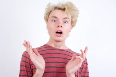 Şaşırmış genç sarışın adam belirsizlikle jestler yapıyor, kameraya bakıyor, şaşırmış bir şekilde hileli soruya cevap vermiyor, insanlar, vücut dili, duygular