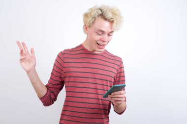 Sarışın genç adam hücresinde oturmuş haberleri okuyor.