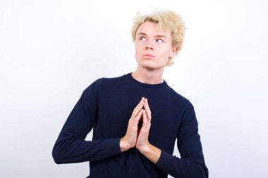 Çekici, neşeli, genç, sarışın bir adam el ele tutuşup bir fikir üretiyor. Bana bak.