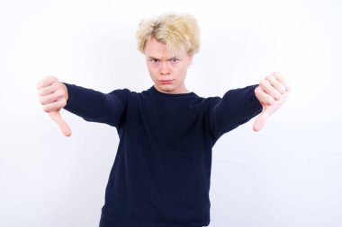 Genç sarışın adam iki eliyle baş parmağını kaldırdığı için üzgün. Konseptten nefret.