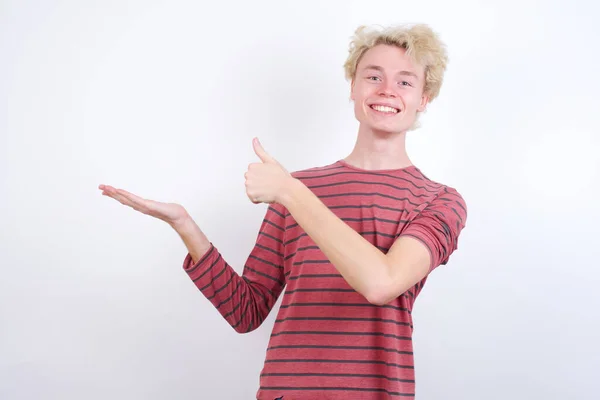 Young Man Showing Palm Hand Doing Gesture Thumbs Smiling Happy — Stock Photo, Image