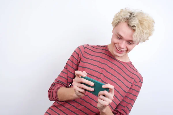Νεαρός Ξανθός Άντρας Που Κρατάει Κινητό Του Παίζοντας Βιντεοπαιχνίδια Κουβεντιάζοντας — Φωτογραφία Αρχείου
