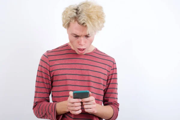 Εστιασμένος Νεαρός Ξανθός Άντρας Χρησιμοποιεί Smartphone Διαβάζοντας Ειδήσεις Στα Μέσα — Φωτογραφία Αρχείου