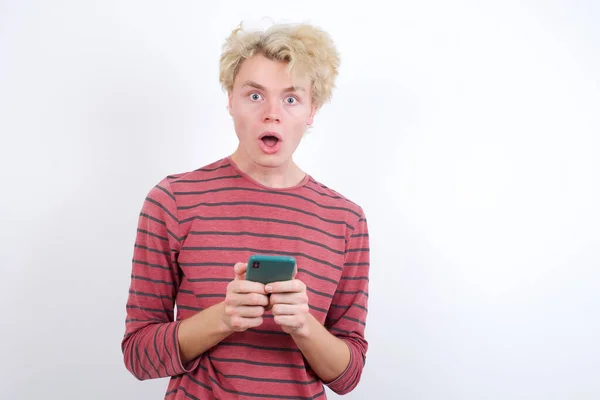 Geschokt Jonge Blonde Man Opent Mond Houden Telefoon Lezen Advertentie — Stockfoto