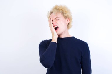 Genç beyaz adam esnemekten yoruldu. Yüzünün yarısını, gözünü ve ağzını eliyle kapadı. Yüzüm acıyor..