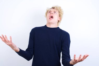 Genç, beyaz, deli bir adam bağırıyor ve bağırıyor. Saldırgan bir ifade ve kollar havada. Hayal kırıklığı konsepti.