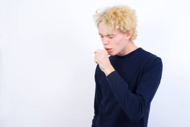 Kafkasyalı genç adam kendini iyi hissetmiyor ve soğuk algınlığı veya bronşitin belirtisi olarak öksürüyor. Sağlık hizmetleri kavramı.