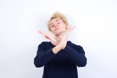 Reddedilmiş genç beyaz adam kollarını kavuşturup negatif işaret veriyor, kızgın surat.