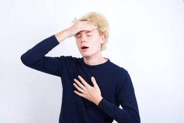 Genç beyaz adam hastalık ve ateş için alnına dokunuyor, grip ve soğuk, virüs hastası..