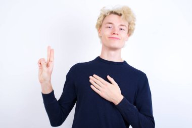 Kafkasyalı genç adam gülümsüyor, elleri göğsünde ve parmakları havada yemin ediyor, sadakat yemini ediyor..