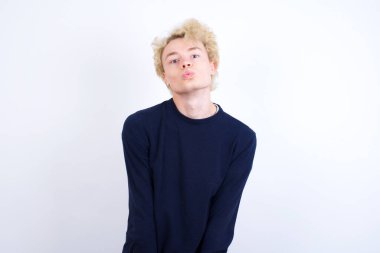 Hoş görünümlü beyaz bir adam, dudaklarını büzüyor, kameraya bakıyor, insan yüz ifadeleri...