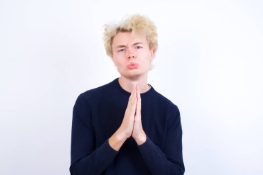 Olumlu genç beyaz adam mutlu bir şekilde gülümsüyor. Müdahaleciden hoş haberler aldığına seviniyor. Avuç içlerini bir arada tutuyor..