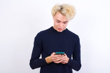 Kafkasyalı genç adam cep telefonu kullanıyor ve boş zamanlarında sohbet ediyor.
