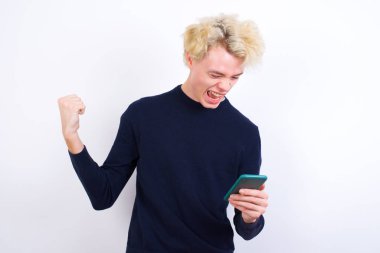 Çekici, neşeli, beyaz bir adam hücresinde oturmuş kitap okuyor.