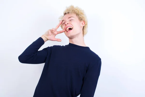 Молодий Білий Чоловік Робить Символ Миру Пальцями Над Обличчям Усміхнений — стокове фото