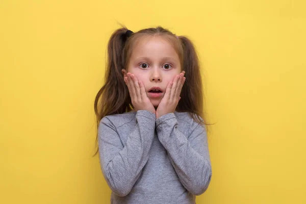 Een Schattig Meisje Een Grijs Shirt Toont Emoties Een Gele — Stockfoto