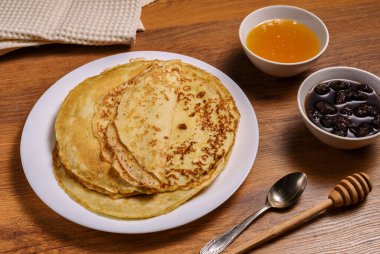 Beyaz tabak ve bal kavanozundaki krep manzarası