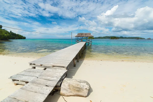 Villaggio turistico e pontile sulla pittoresca spiaggia tropicale in Indonesia — Foto Stock