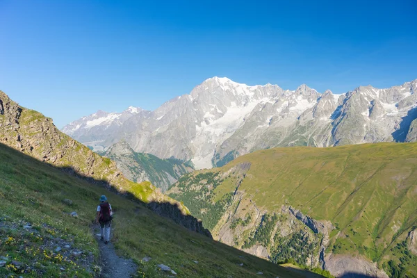 Mochilero senderismo en los Alpes, majestuoso Mont Blanc en el fondo —  Fotos de Stock