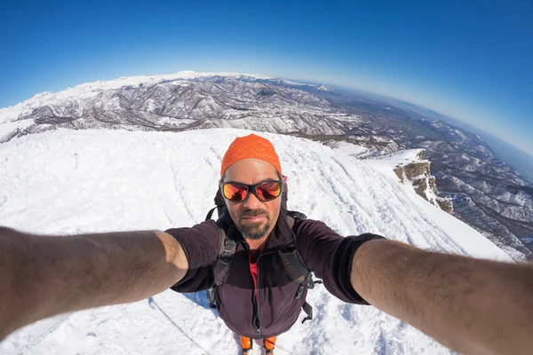 Alpinista scattare selfie su montagna innevata, lente fisheye — Foto Stock