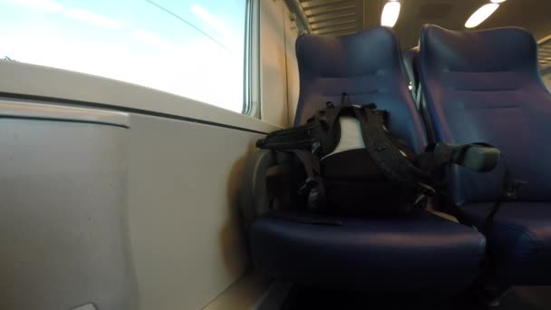 Backpack on the seat of a riding train. — Stock Video