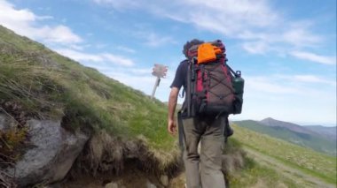 Backpacker ve fotoğrafçı İtalyan Alpleri'nde yürüyüş, durdurma ve tabela bakarak.