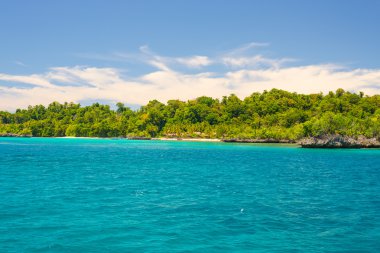 Adası'nın kayalık sahil adacıkları tarafından tespit ve merkezi Sulawesi, Endonezya uzak Togean Adaları (veya Togian Adaları), renkli deniz yoğun yemyeşil yeşil orman kapsadığı.