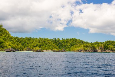 Adası'nın kayalık sahil adacıkları tarafından tespit ve merkezi Sulawesi, Endonezya uzak Togean Adaları (veya Togian Adaları), renkli deniz yoğun yemyeşil yeşil orman kapsadığı.