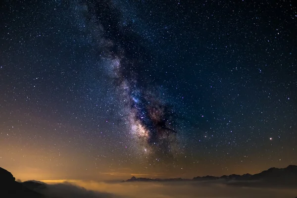 The colorful glowing core of the Milky Way and the starry sky captured at high altitude in summertime on the Italian Alps, Torino Province. Mars and Saturn on the right. — Stock Photo, Image