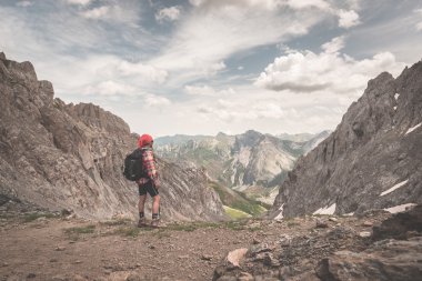 Backpacker kaldırımüzerinde yürüyüş ve yukarıdan geniş bir görünüme bakıyor. İtalyan Fransız Alpleri'nde yaz maceraları ve keşifler. Tonda retro vintage tarz görüntü.