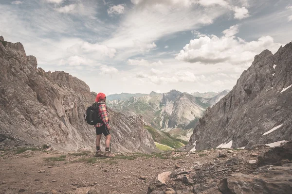 Mochilero de senderismo en el sendero y mirando a la vista expansiva desde la parte superior. Aventuras de verano y exploración en los Alpes franceses italianos. Tonificado imagen estilo vintage retro . — Foto de Stock