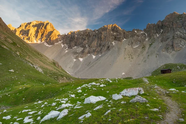 Prado alpino e pasto situado em meio a alta altitude gama de montanhas ao pôr do sol. Os Alpes italianos, famoso destino de viagem no verão . — Fotografia de Stock