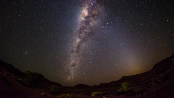 在纳米比亚纳米布沙漠的山外，一个极其明亮的银河系和星空的明显旋转。时移 4k 视频. — 图库视频影像