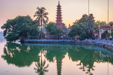 Hanoi Budist tapınağı (Tran Quoc Pagoda) Hanoi 'deki Batı Gölü' nde, renkli günbatımı, aydınlık tapınak, su yansıması. Vietnam seyahati.