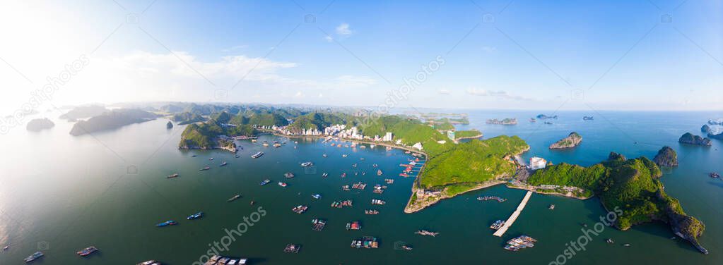 Aerial unique view Vietnam Cat Ba bay with floating fishing boats on sea, cloudscape tropical weather inspirational sunset, epic city skyline and skyscraper, scenic green mountain.