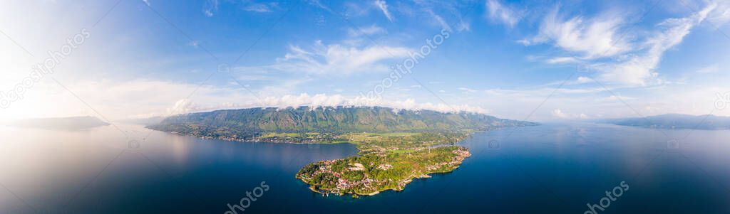 Aerial: lake Toba and Samosir Island view from above Sumatra Indonesia. Huge volcanic caldera covered by water, traditional Batak villages, green rice paddies, equatorial forest.