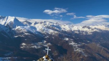 İtalya Alpleri 'nin kış mevsiminde karlı dağ zirveleri ve tepeleri üzerindeki panorama, açık güneşli gökyüzü