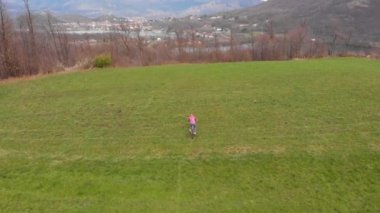 Hava manzarası: Alpler 'in kırsalında bisiklet süren bisikletçi, yeşil tepeler manzarası, özgürlük fitness sporu başarı kavramı