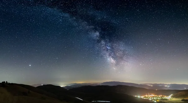 イタリアのSanto Stefano Sessanio Abruzzo Rocca Calascioのパノラマの夜空 天の川銀河弧と照明村のユニークな丘の風景の上の星 木星の惑星が見える — ストック写真