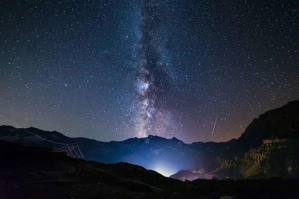 天の川銀河とイタリアアルプスの上の星 雄大な雪の山や氷河の夜空 右側の流星群 左側の木星型惑星 — ストック写真