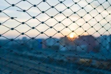 Metal çit ötesinde bulanık cityscape