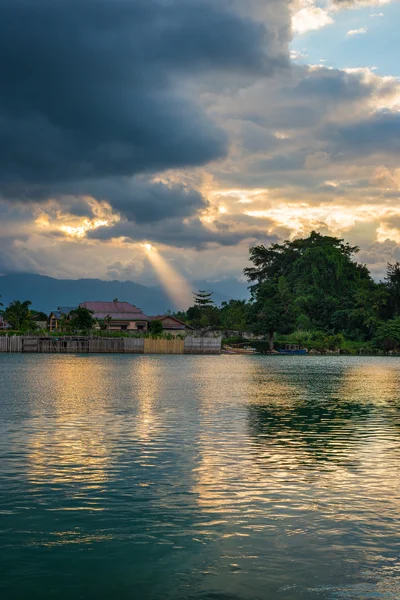 Paysage nuageux et rayons de soleil sur le lac — Photo