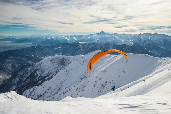 Paraglider startas från snöig backe — Stockfoto