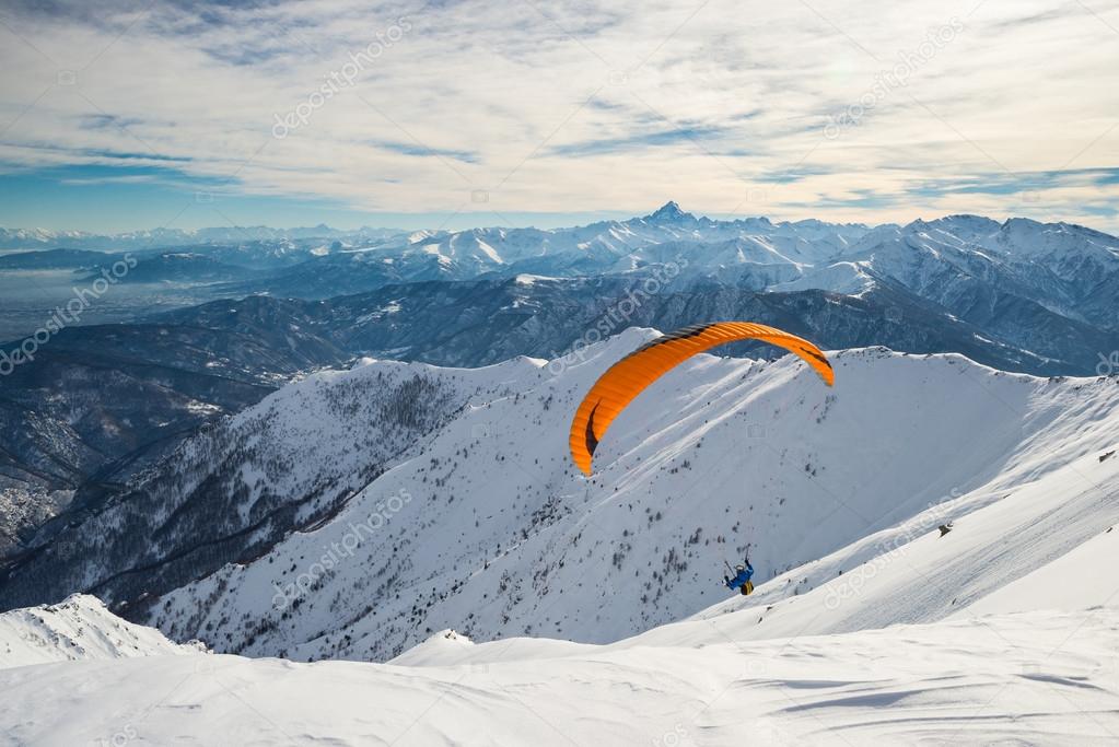 Paraglider launching from snowy slope
