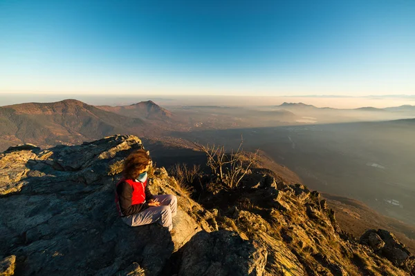 Mujer descansando en la cima de la montaña —  Fotos de Stock