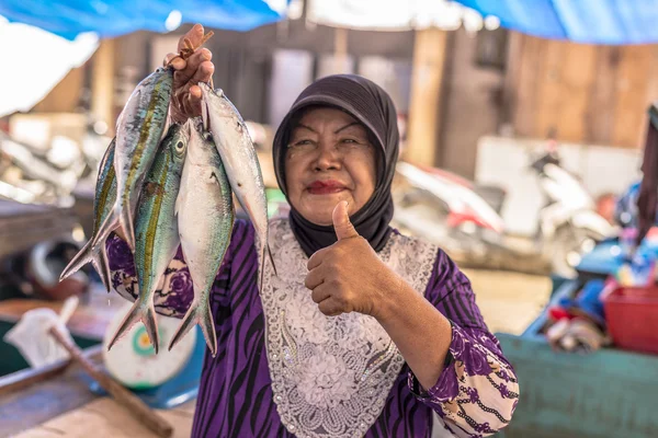Mulher vendendo peixes no mercado local Fotos De Bancos De Imagens