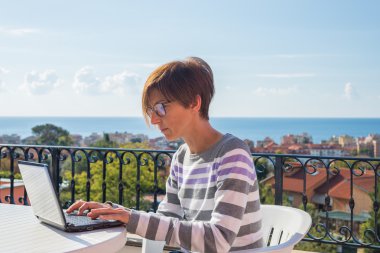 Woman working with netbook outdoors clipart