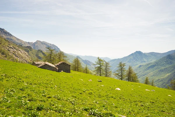 Cabanas de pedra alpinas em paisagens verdes incríveis — Fotografia de Stock